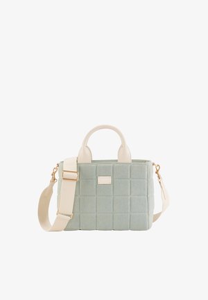 Sac à main matelassé vert clair avec des poignées beige et une bandoulière beige réglable, avec une plaque de marque dorée à l'avant.