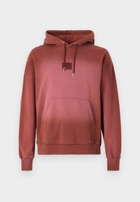 Red hooded sweatshirt made from soft fabric, featuring a front pocket, ribbed cuffs, and a small logo patch on the chest.