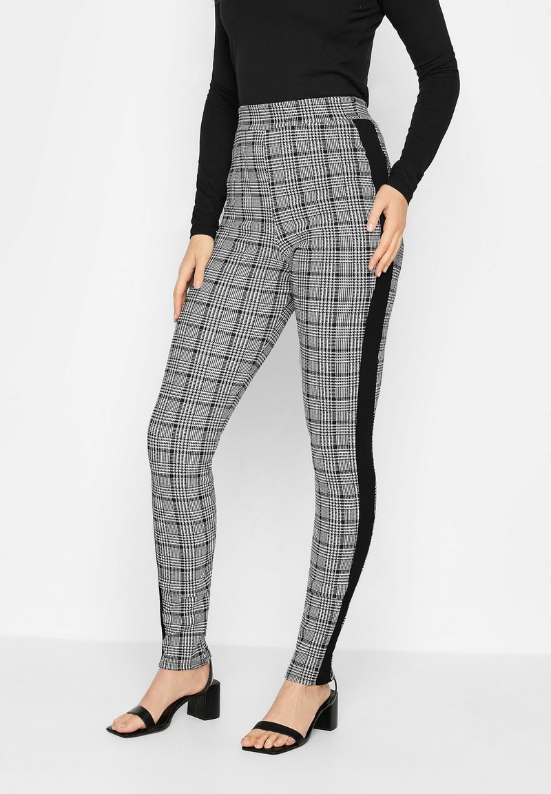 Högmidjade rutiga byxor med en svart sidopanel, tillverkade av ett stretchigt material, designade för en figurnära silhuett.