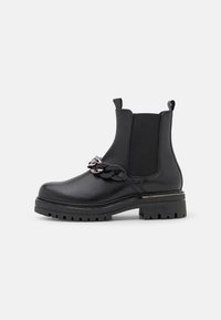 Bottes noires en cuir avec des panneaux élastiques sur les côtés, semelle épaisse et accent de chaîne décoratif. Surface texturée et conception durable.