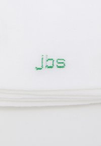 Weißer Stoff mit strukturierter Oberfläche, auf dem in grüner Stickerei der Text "jbs." zu lesen ist. Der Stoff ist ordentlich in Lagen gefaltet.