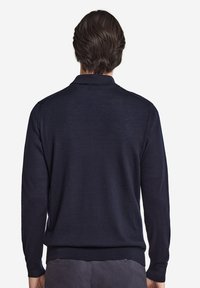 Mörkblå tröja med långa ärmar och ribbat nederkant, med en enkel, slät textur och en klassisk polo-krage design.