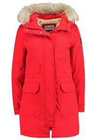Rode, geïsoleerde parka met een capuchon van kunstbont, ritssluiting en twee voorzakken. Zacht binnenvoering en verstelbare taille.