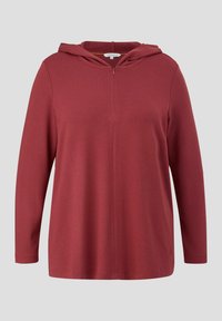 Maroon dukserica s dugim rukavima i patentnim zatvaračem sprijeda, s suptilnim detaljima šavova i mekanom teksturom. Sadrži kapuljaču s drškom i minimalistički dizajn.