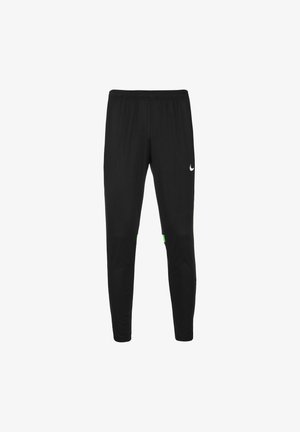 Czarne spodnie sportowe z elastycznym paskiem, tapered design, logo Nike w białym kolorze oraz zielone akcenty po bokach. Lekka, teksturowana tkanina.