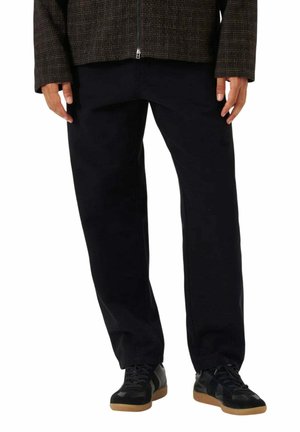 Zwarte broek, taps toelopende pasvorm, rechte pijpen, gemaakt van katoen. Gecombineerd met donkere sneakers met een gestructureerde zool. Fijne designdetails zichtbaar.