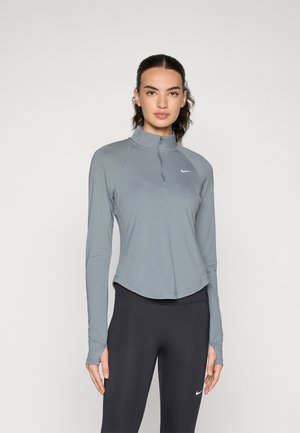 Langsleeve, zip-nekl pullover van lichtgrijze stof met een getailleerd ontwerp. Het heeft een gebogen zoom en een klein wit logo op de borst.