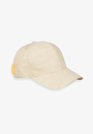 Gorra de béisbol de tela beige con visera curva y pequeña etiqueta amarilla en el lateral, mostrada sobre un fondo blanco.