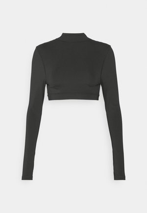 Juodas ilgomis rankovėmis trumpas viršus iš lygaus audinio, su aukštu kaklu ir prigludusia forma, su minimaliais siūlių akcentais ties apačia.