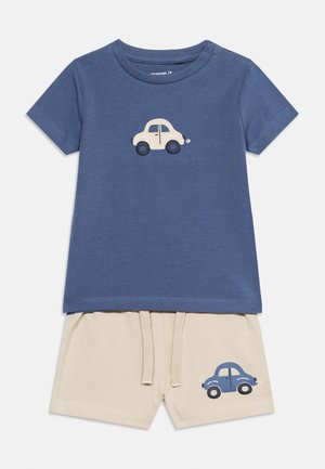 Maglietta blu a maniche corte per bambino con stampa di macchina beige, abbinata a pantaloncini beige con stampa di macchina blu e vita regolabile con coulisse.