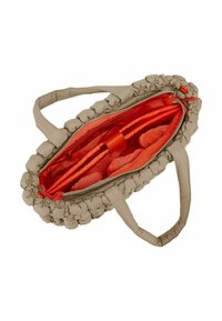 Sac en tissu beige avec une texture froncée, fermeture éclair et intérieur rouge vif. Dispose de deux poignées et de plusieurs compartiments intérieurs.