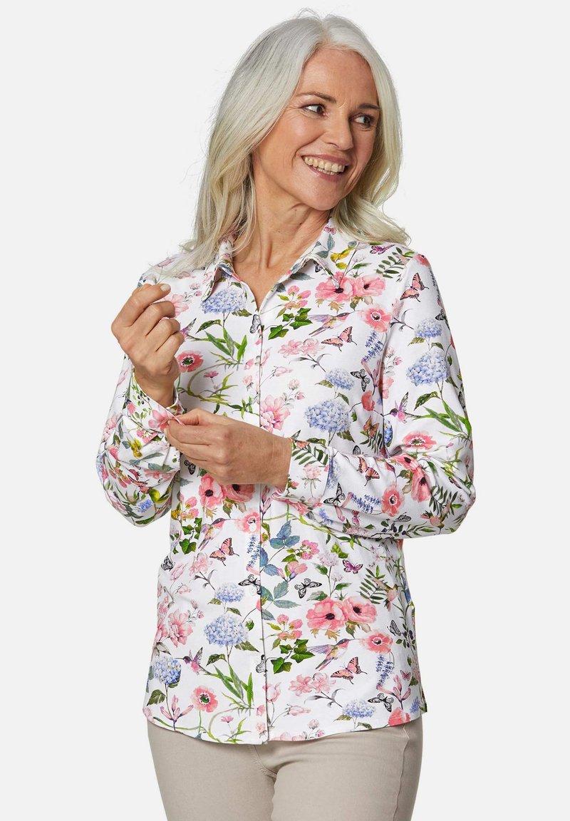 Weißes Hemd mit Knopfleiste, das ein florales Muster mit rosa, blauen und grünen Akzenten zeigt; lange Ärmel; glatte Stofftextur.