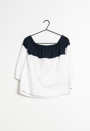 White top with navy blue gathered neckline and three-quarter sleeves. Features a relaxed fit and curved hem, made from lightweight fabric.