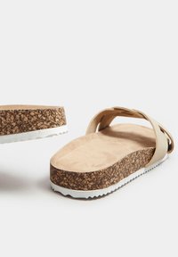 Sandales à glisser beiges avec semelle en liège, dessus en daim lisse et semelle extérieure en caoutchouc blanc ; caractéristiques de larges brides pour un maintien sécurisé.