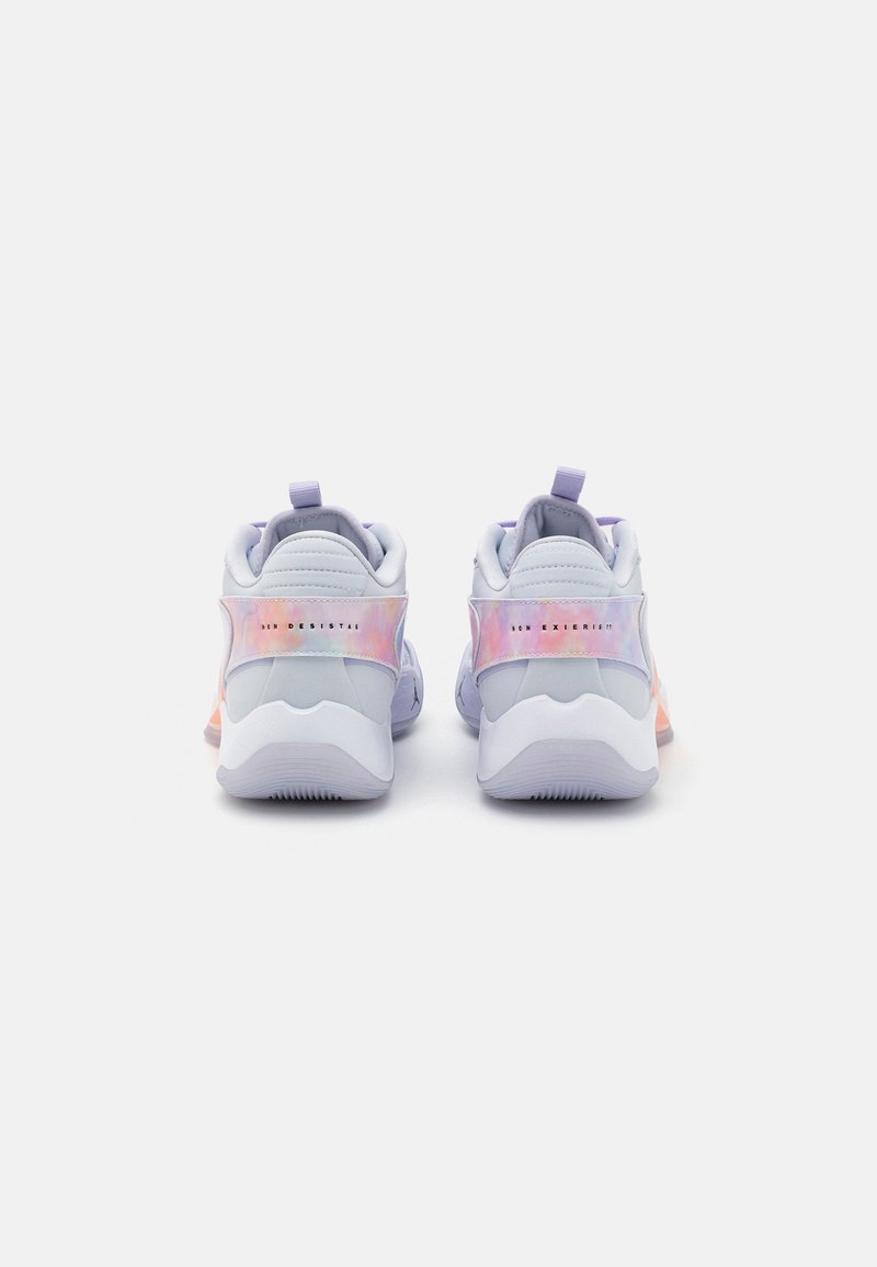 Zapatillas de color púrpura claro con una textura suave, acentos iridiscentes y una suela blanca en contraste, con una pestaña trasera para facilitar el calzado.