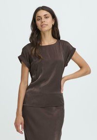 Brun satin kortærmet top med rund halsudskæring og afslappet pasform. Glat tekstur med opskudte ærmer og et enkelt silhuet.