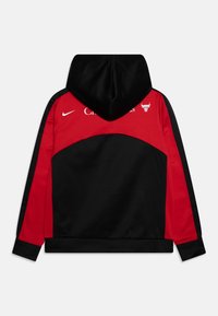 Felpa nera e rossa con tasca a marsupio frontale, dotata di cappuccio, logo Nike e logo della squadra sportiva sul retro. Tessuto dalla consistenza liscia.
