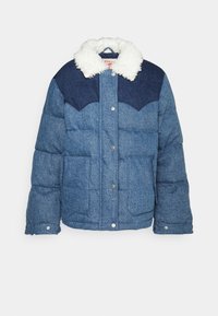 Veste en jean bleu matelassée avec un empiècement foncé et un col en fausse fourrure blanche, boutons pression sur le devant et deux grandes poches avant.