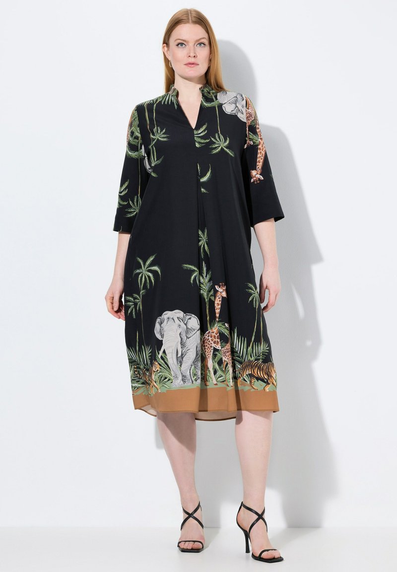 Schwarzes Kleid mit kurzen Ärmeln, das mit Tier- und tropischen Pflanzenmustern versehen ist. V-Ausschnitt-Design mit gefaltetem Vorderteil und braunem Saum.