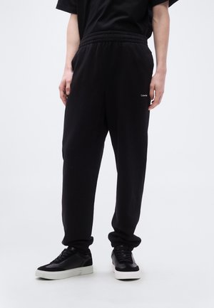 Melnas sporta bikses ar brīvu piegriezumu, elastīgu vidukļa jostu, sānu kabatām un smalku zīmolu. Izgatavotas no mīksta, gluda auduma.