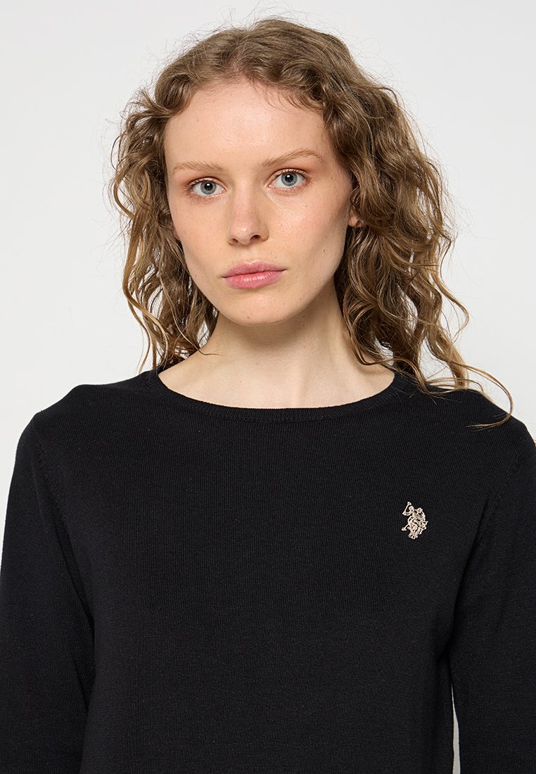 Schwarzer Strickpullover mit rundem Ausschnitt, strukturiertem Stoff und kleinem gesticktem Logo auf der linken Brust.