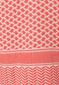 Tejido textil con un patrón repetitivo de peces en color coral rosa sobre un fondo claro, con líneas horizontales contrastantes en la parte superior e inferior.