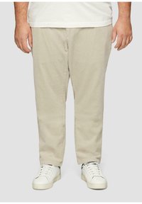 Beige corduroy broek met een rechte snit, voorzien van subtiele verticale strepen, gecombineerd met witte sneakers. Losse pasvorm met een soepele textuur.