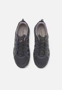 Svarte tursko med teksturert stoff, gummisåle, forsterket tå og elastiske snøringer. Har Gore-Tex-merke på siden.
