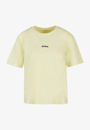 Žluté tričko vyrobené z bavlny s kulatým výstřihem. Má krátké rukávy a na hrudi je potištěný text "GirlGang" v černé barvě.