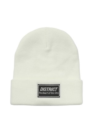 Beanie lavorato a maglia di colore crema con risvolto, caratterizzato da un'etichetta nera rettangolare con testo bianco. Texture liscia, design semplice.
