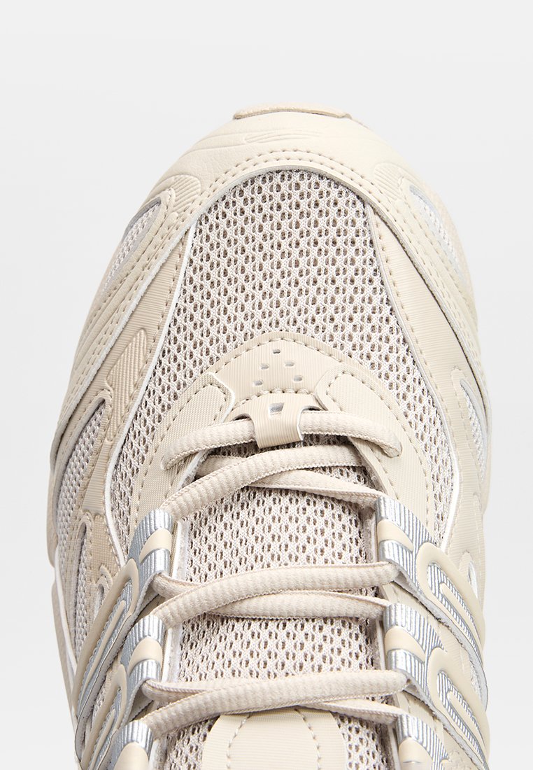 Beige Sportlich Sneaker mit einem strukturierten Mesh-Obermaterial, silbernen Akzenten und Schnürverschluss. Runde Zehenpartie und gepolsterte Sohle.