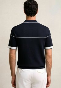 Jūras spēku poloshirts ar baltu apdari apkaklī un piedurknēm, ar horizontālu baltu svītru aizmugurē, matēta tekstūra.