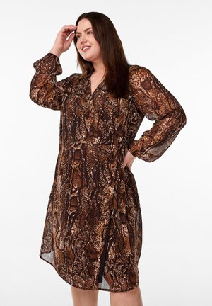 Bruine slangenprint jurk met lange doorschijnende mouwen, een v-hals en een getailleerde taille. Beschikt over een zijslit en een lichtgewicht materiaal.