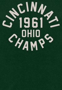 Tmavě zelená mikina s bílým textem, který zní "CINCINNATI 1961 OHIO CHAMPS." Tučné písmo v blokovém stylu s zakřiveným designem.