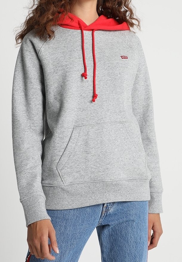 Sweat-shirt gris avec capuche et cordons rouges, doté d'une poche kangourou à l'avant et d'un petit logo. Fabriqué en tissu doux et texturé.