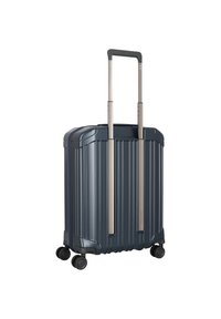 Valigia rigida di colore blu scuro con scanalature verticali. Presenta due maniglie in alluminio estensibili e quattro ruote rotanti per una maggiore mobilità.