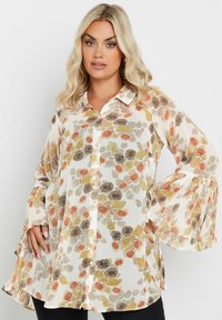 Floral-patterned blouse in translucent fabric featuring shades of orange, brown, and yellow. Button-down front with flared sleeves.