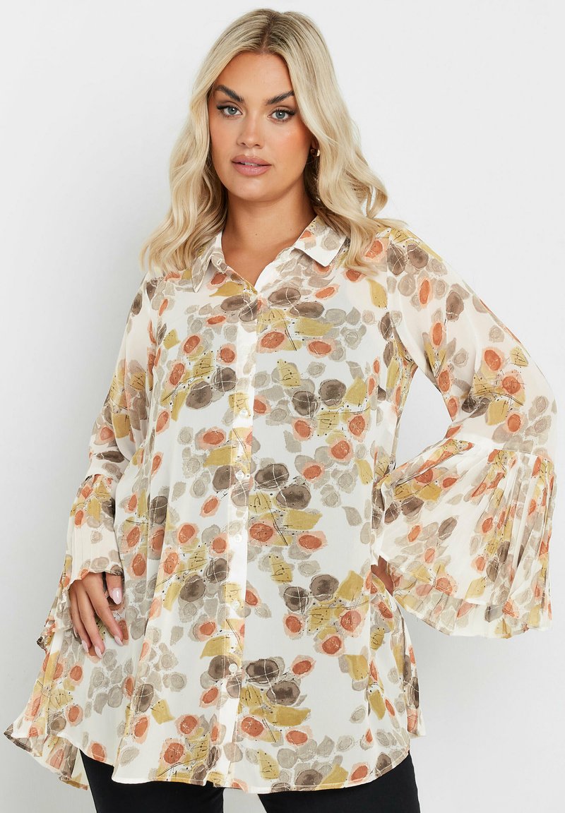 Floral-patterned blouse in translucent fabric featuring shades of orange, brown, and yellow. Button-down front with flared sleeves.