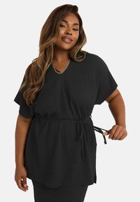 Tunique noire texturée avec un col en V et des manches courtes, dotée d'une ceinture à nouer à la taille. Design ample, décontracté et confortable.