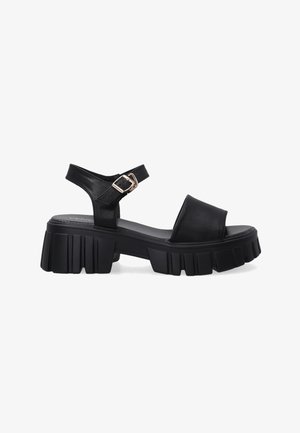 Schwarze Leder-Sandalen mit dicker Sohle, offener Zehenpartie und Knöchelriemen mit einem Metallschließen-Detail. Flacher, strukturierter Fußbett für Komfort.