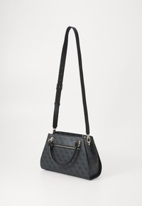 Black leather handbag with a structured shape, features a front zip pocket, double handles, and an adjustable strap, detailed with gold hardware.