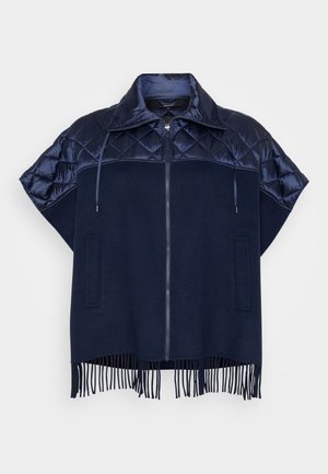 Capa azul-marinho com fecho à frente, ombros acolchoados em matelassê, gola com cordões ajustáveis, bolsos frontais e franja ao longo da bainha.