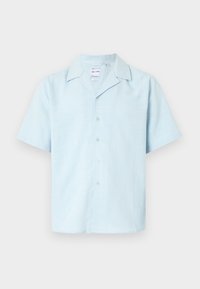 Chemise à manches courtes en tissu bleu clair, avec un col cranté et une texture douce agrémentée d'un motif subtil, six boutons sur le devant.