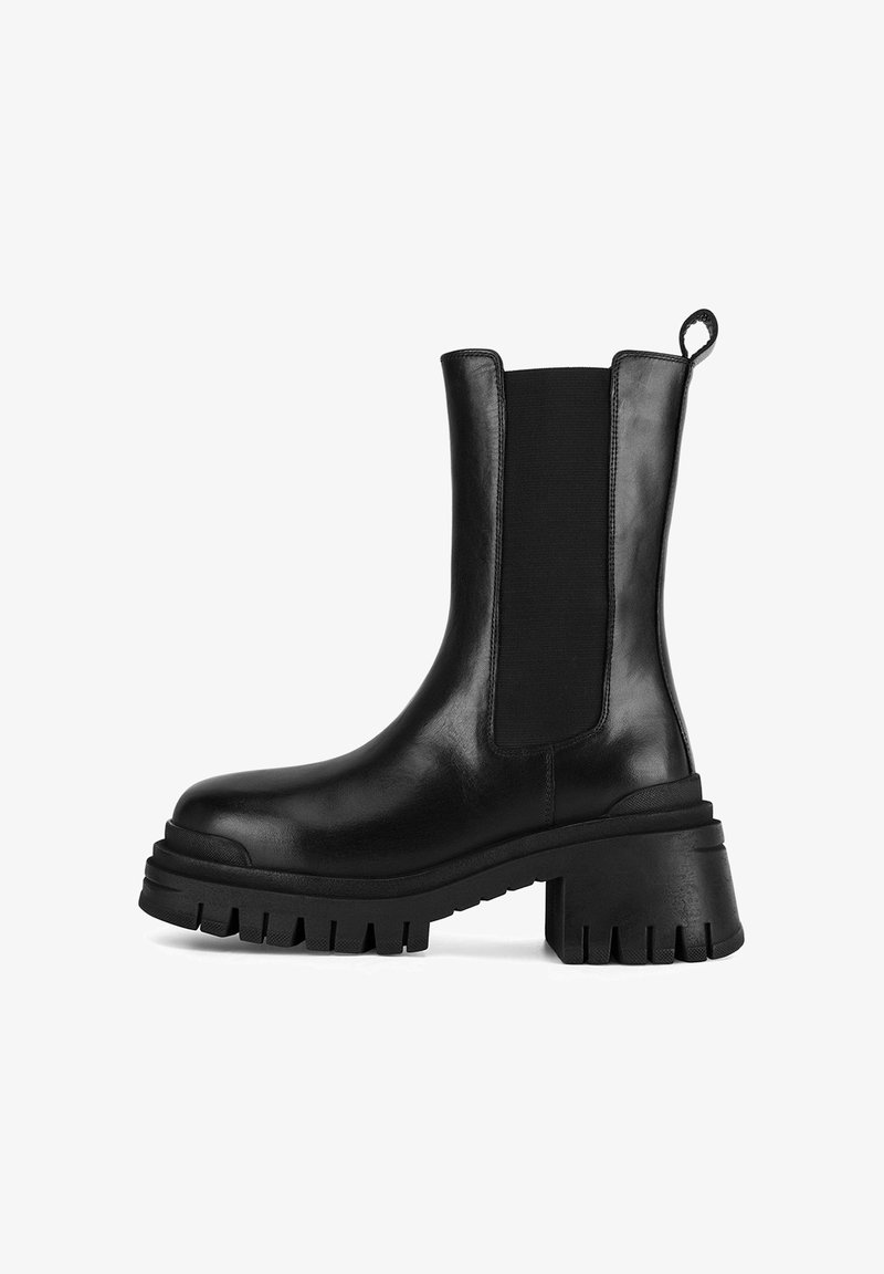 Cizmă de gleznă din piele neagră, cu panouri elastice pe laterale, toc masiv și talpă din cauciuc texturat. Finisaj neted cu detaliu de maner.