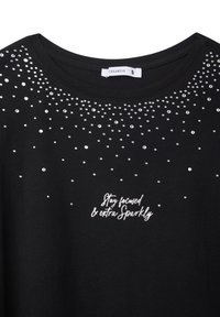 T-shirt nera con scollatura rotonda, decorata con strass argentei e testo ricamato bianco "Rimani concentrato e extra scintillante."