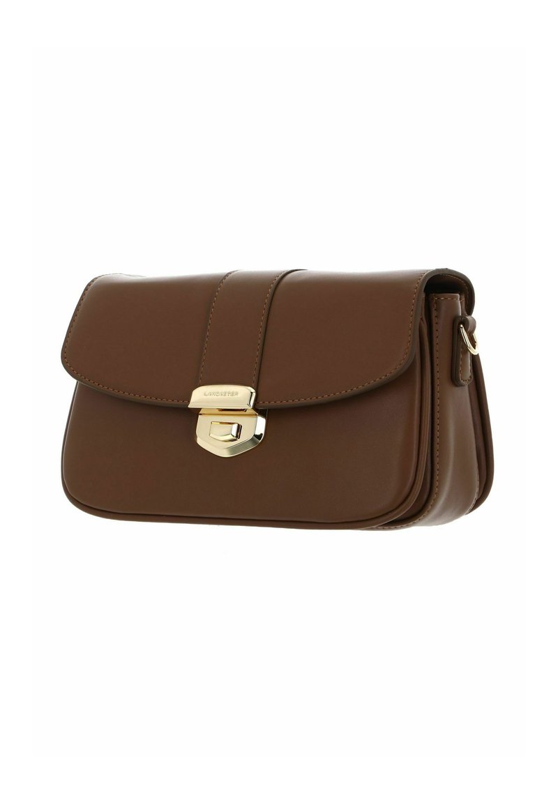 Sac à main en cuir marron avec une fermeture à rabat, des finitions en or et une texture lisse. Présente des coutures et un design compact.