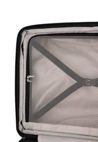 Open koffer met beige interieur, zwarte gaasritsdivider en zwarte verstelbare riemen die een X-vorm vormen.