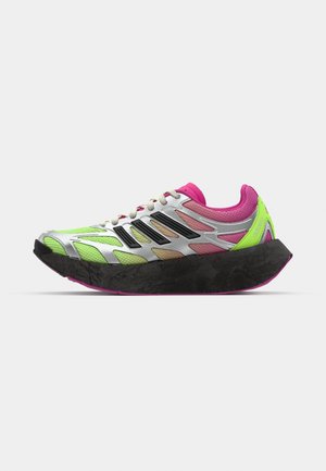 Sportssko med sølvfarget mesh-overdel, neon grønne detaljer, rosa elementer og en tykk svart såle. Har snøring og slitesterke materialer.