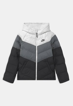 Nike Steppjacke mit Kapuze in Weiß-, Grau- und Schwarz-Tönen im Chevron-Muster und Frontreißverschluss.