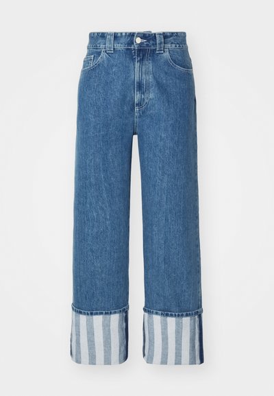 Τζιν παντελόνι σε μέτριο μπλε χρώμα με φαρδιά πόδια, που διαθέτει μανσέτα με μπλε και λευκές κάθετες ρίγες. Κλασικός σχεδιασμός πέντε τσεπών με κούμπωμα.